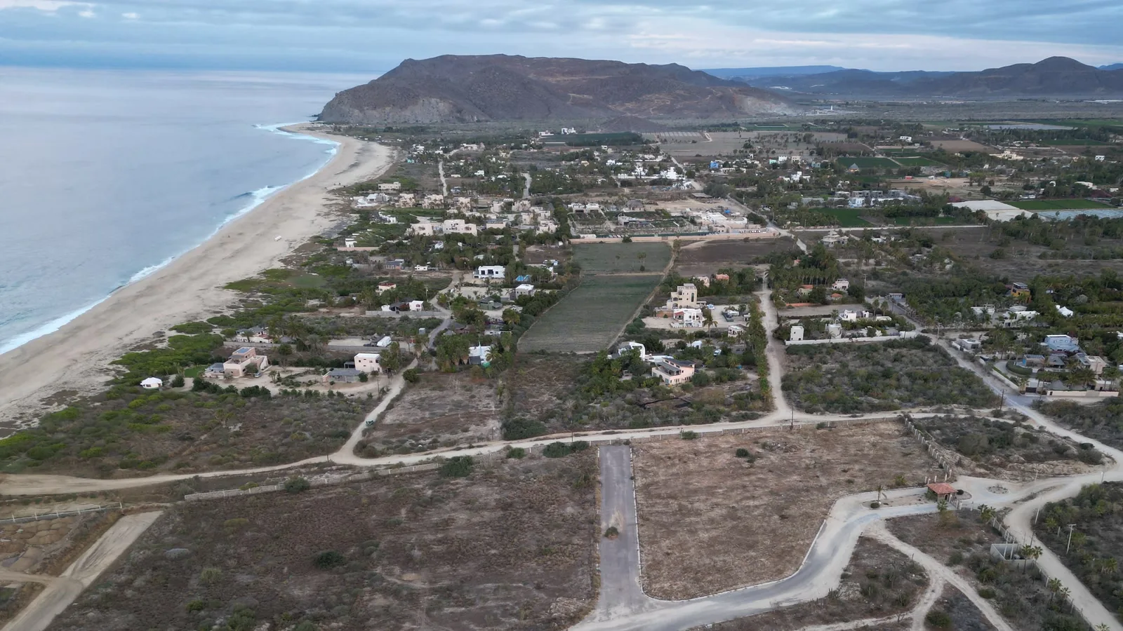Aerial view over El Pescadero farmland, coast, and hills